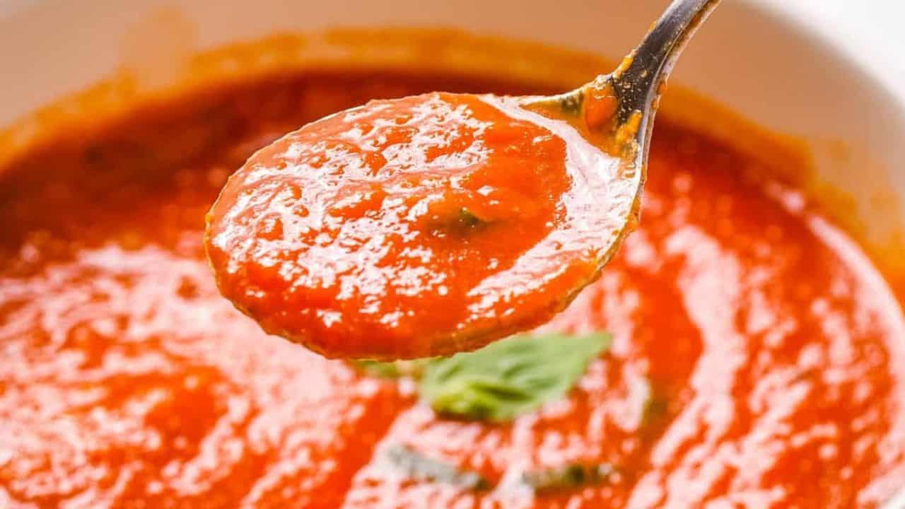 Close up of Instant Pot Tomato soup in a white bowl, with grilled cheese next to it.