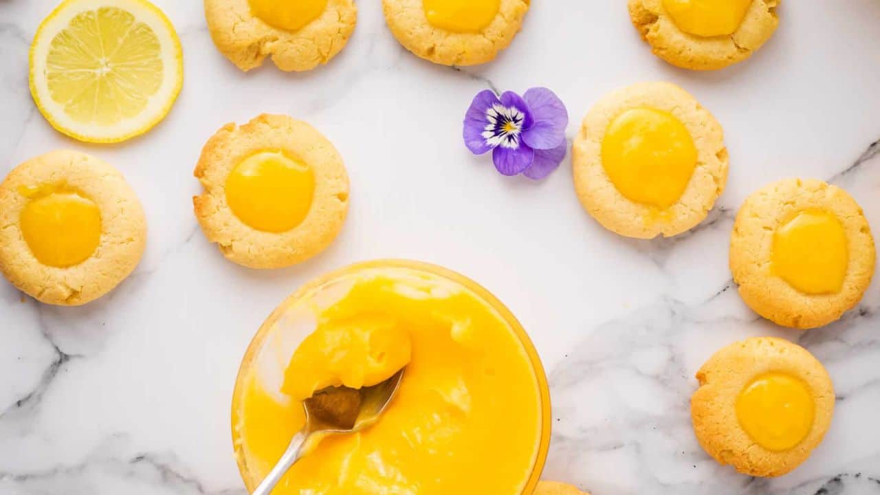 Close up view of lemon curd cookies with a lavender flower in background.