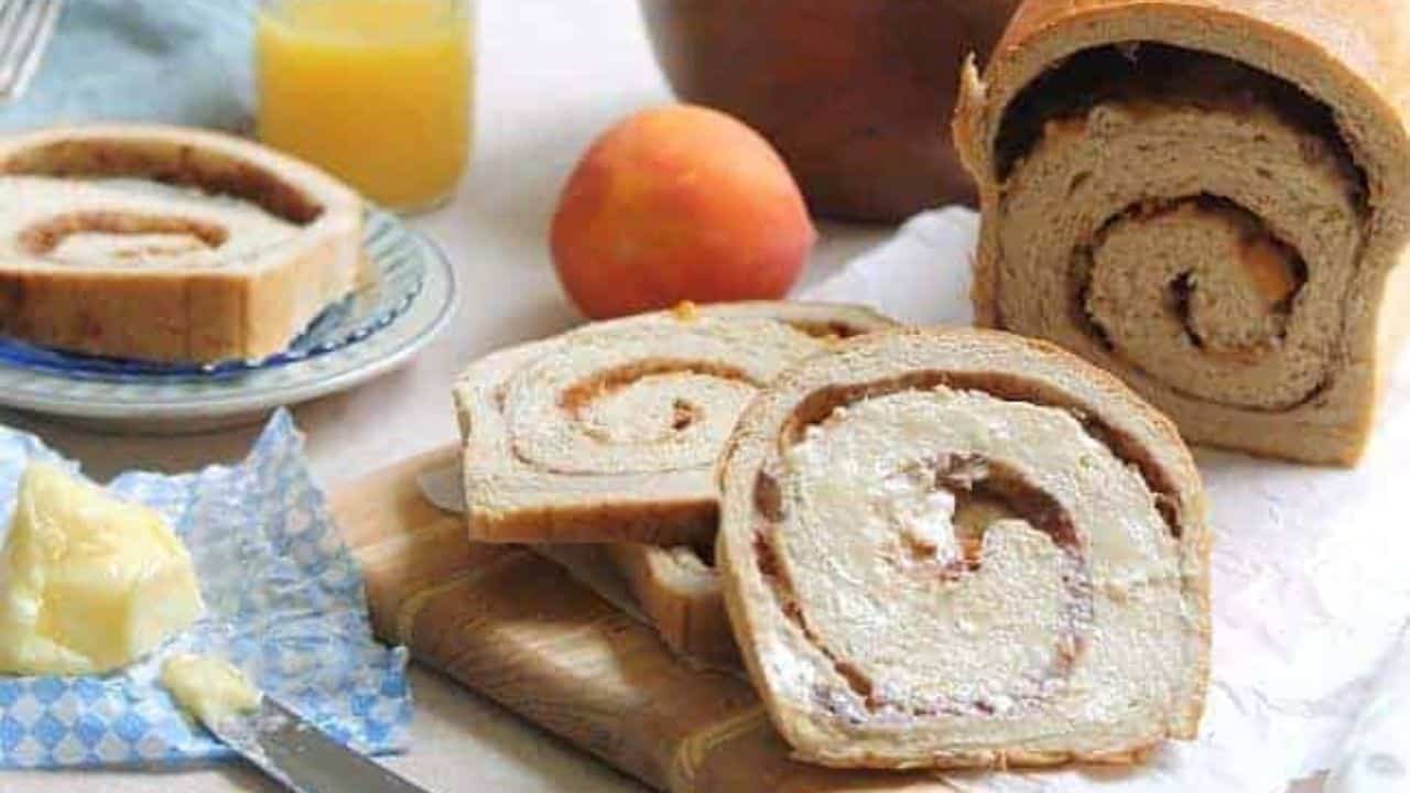 Loaf of roasted peach cinnamon swirl bread with two slices cut off.