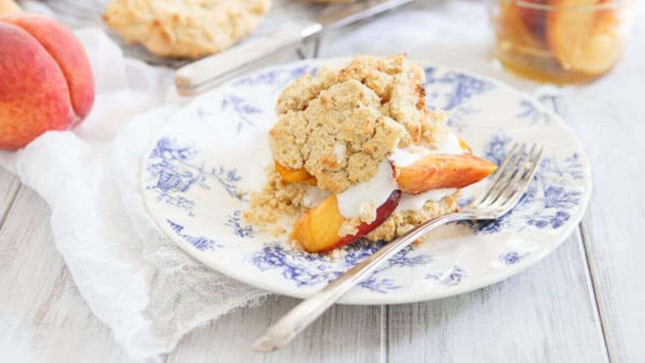 Peach shortcake on a blue and white plate with a fork.