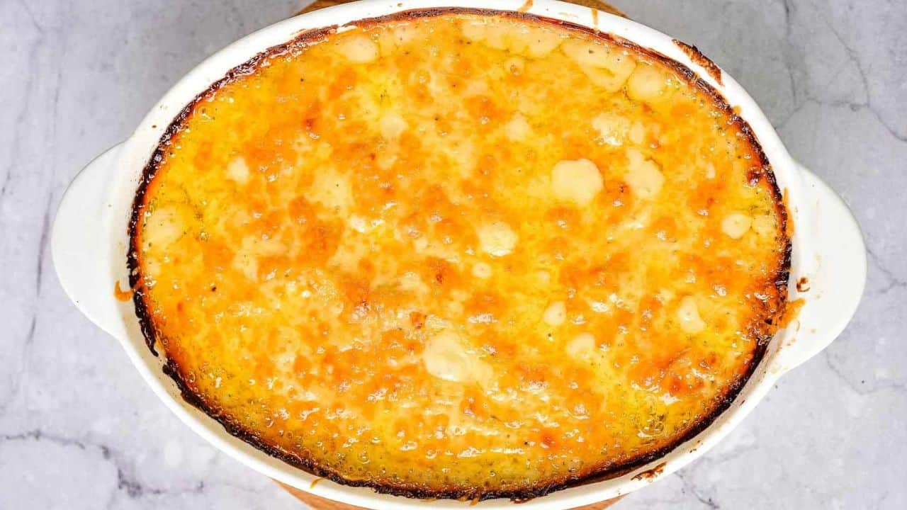 Overhead shot of potatoes au gratin cooked in an oval baking dish.