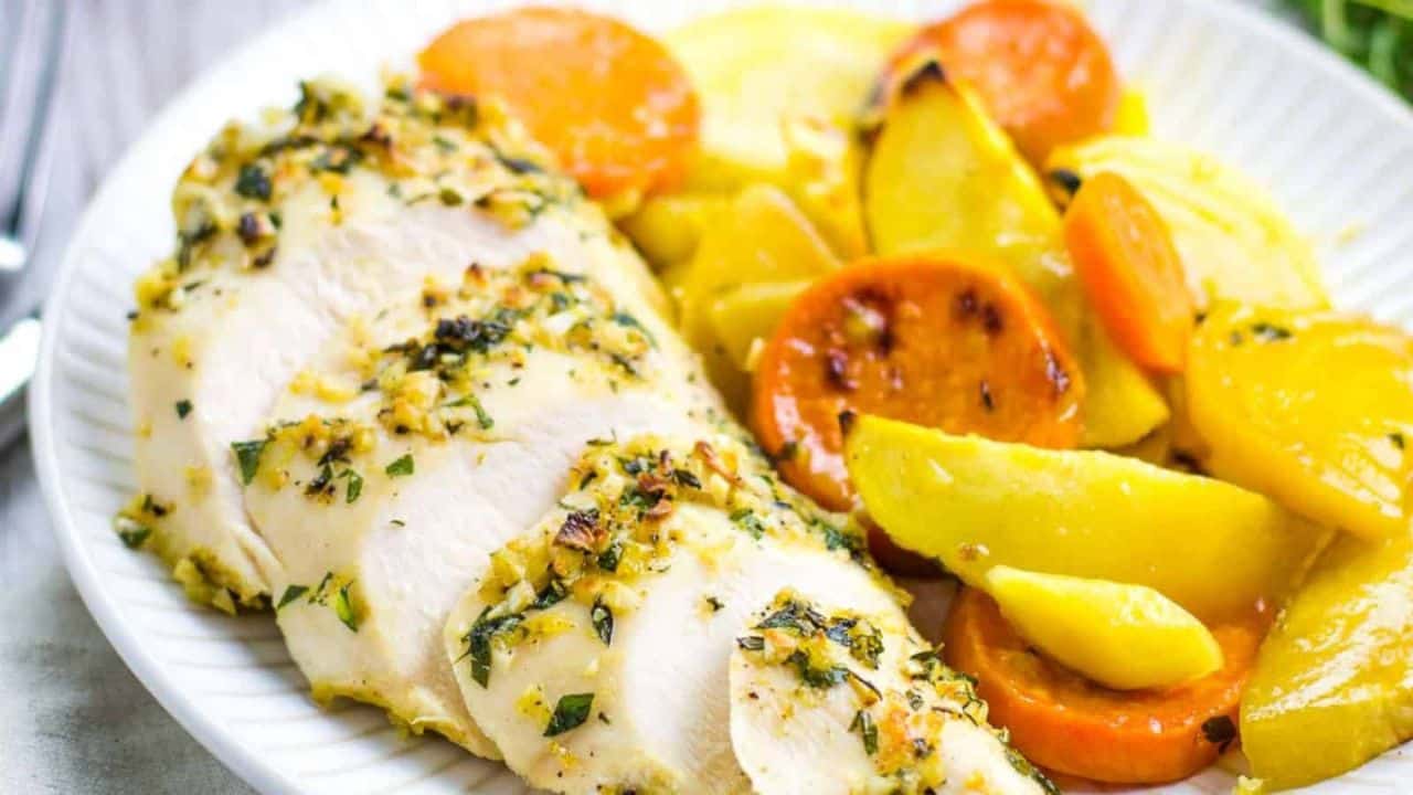 Roasted chicken and vegetables in a skillet on a cutting board.