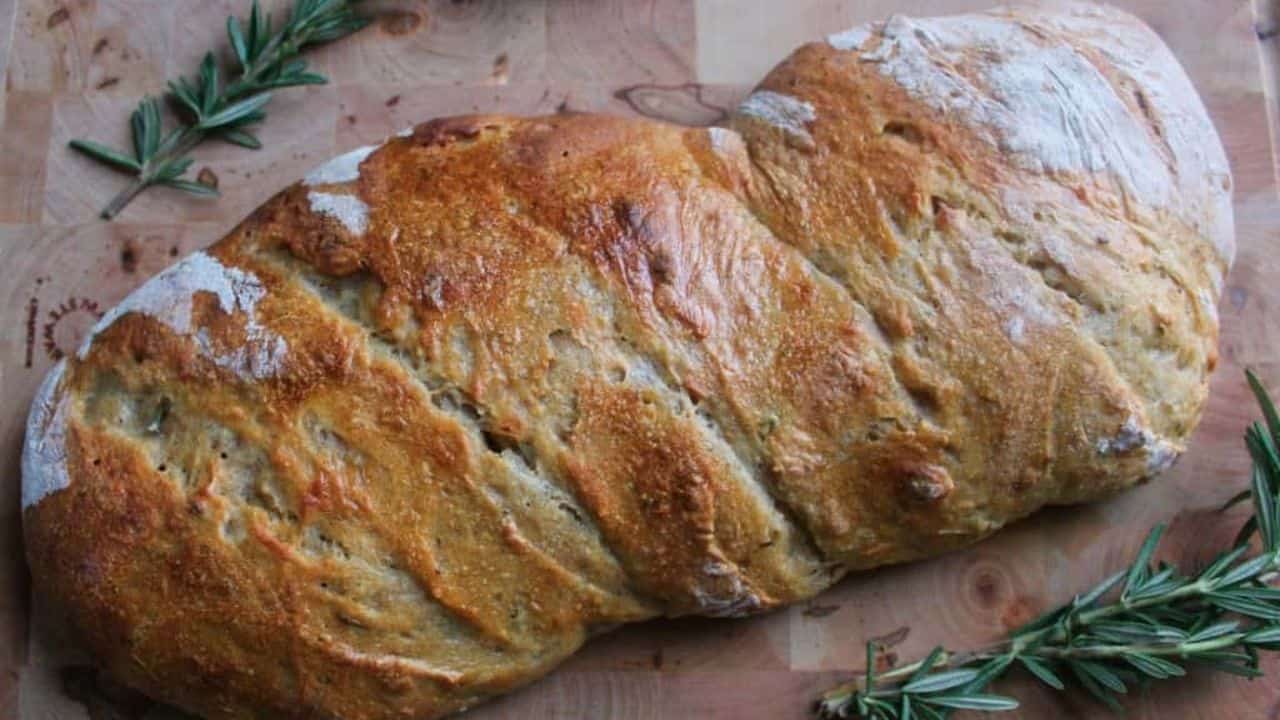 Rosemary sourdough bread on cutting board.