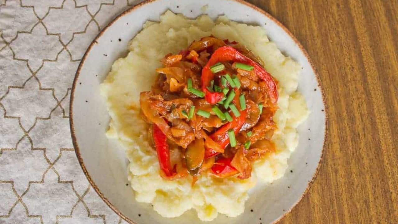 A plate with mashed potatoes and meat on it.