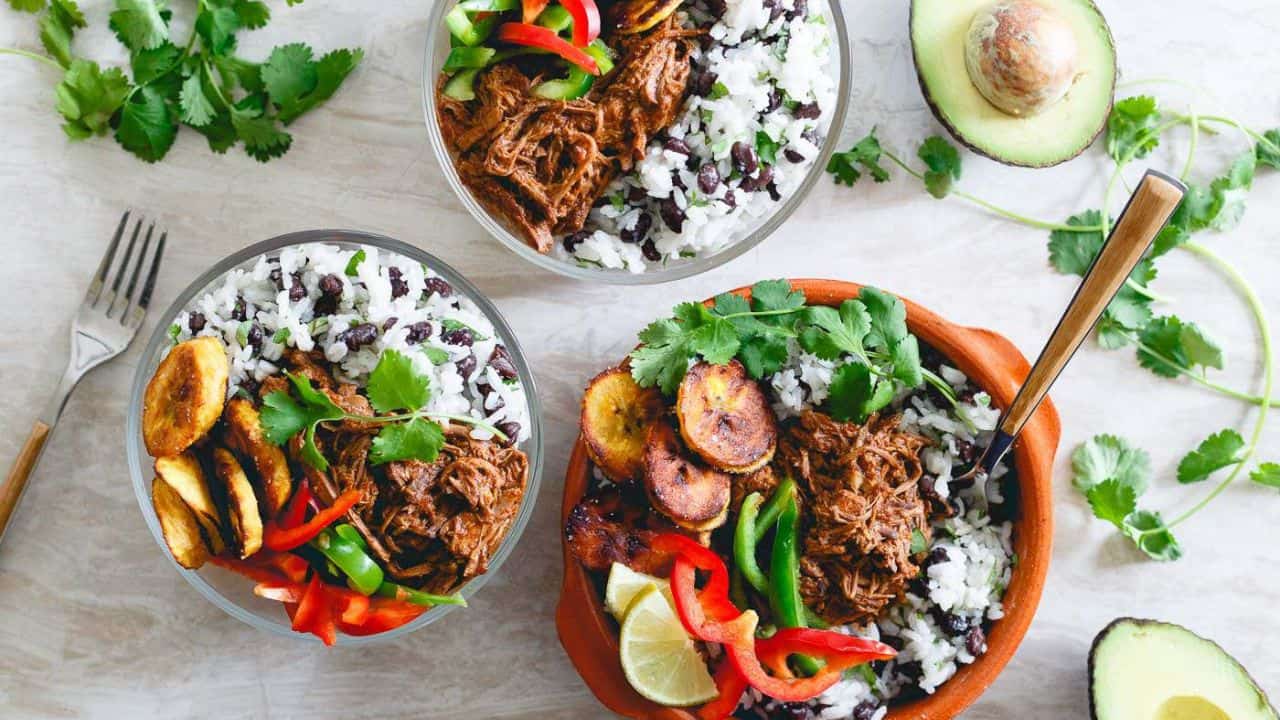 Mexican shredded beef bowls with plantains, rice and beans and peppers.