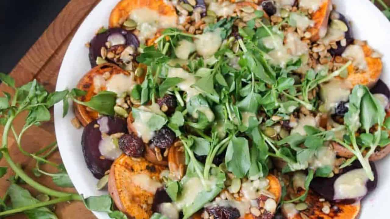 A white plate with sweet potatoes and greens on it.