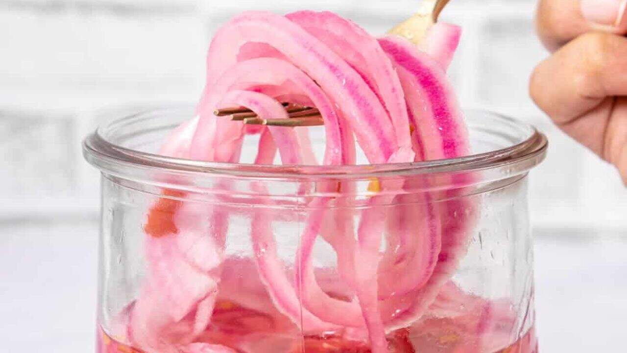 Top view of sweet and spicy pickled onions in a jar.