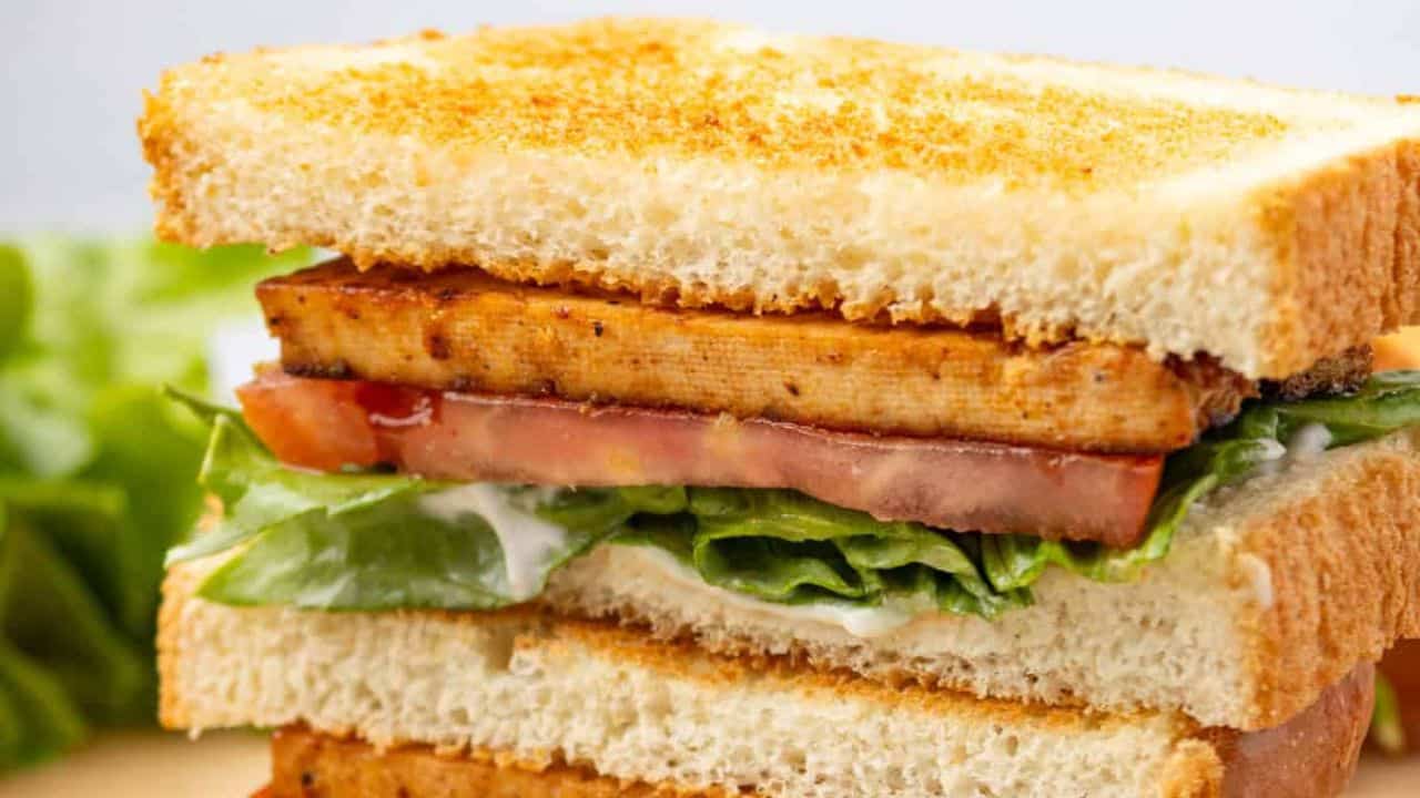 A close up image of the tofu BLT sandwich on a serving board.