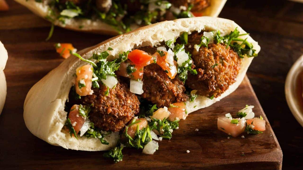 Low angle shot of falafel in a pita with parsley and tomatoes.