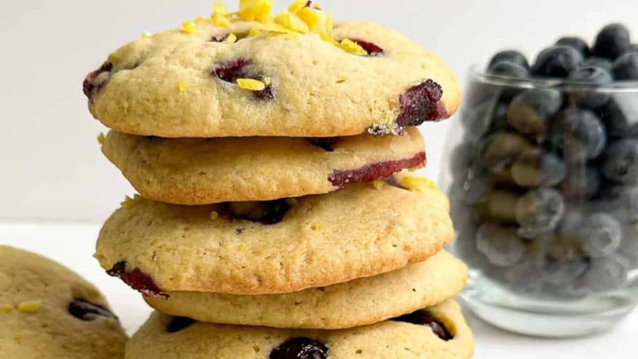Soft lemon cookies bursting with fresh blueberries on a plate.