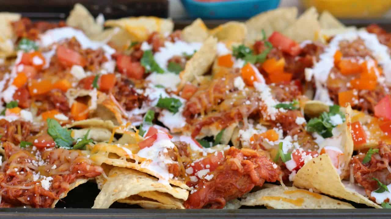 Sheet pan of nachos - topped with pulled pork, cheese, veggies, etc.