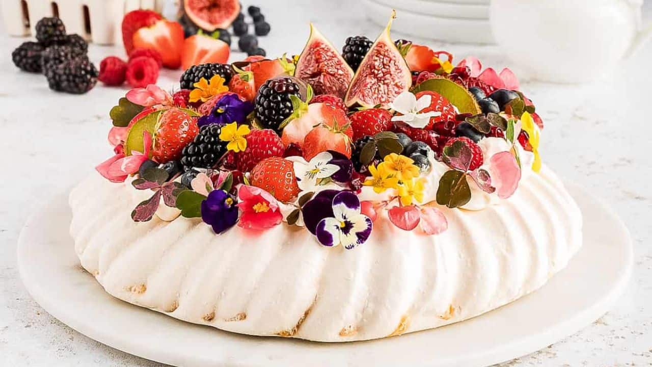 A pavlova topped with berries and figs.