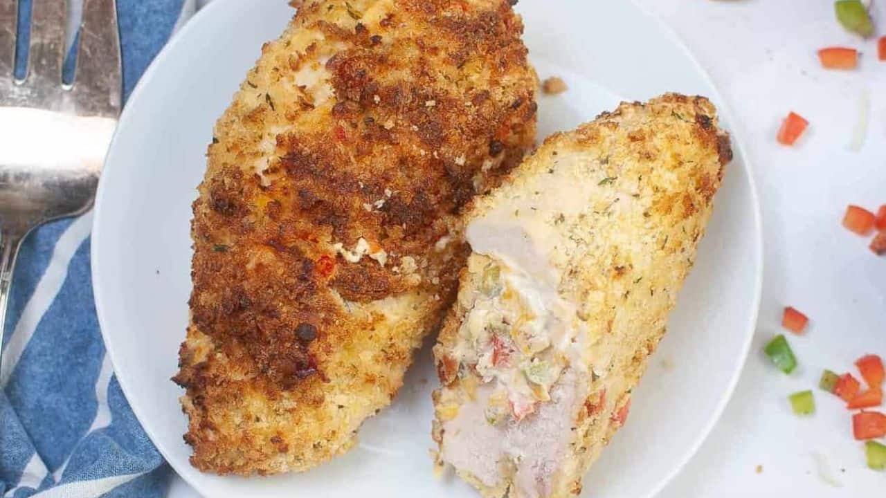 Chicken breasts on a plate with vegetables around it.