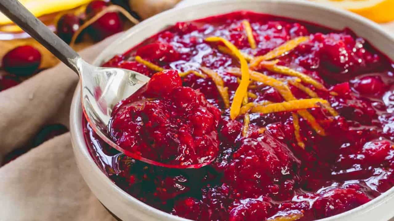 Bourbon cranberry sauce in a white bowl with orange slices.