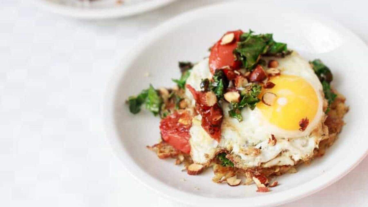 A plate topped with a fried egg and greens.