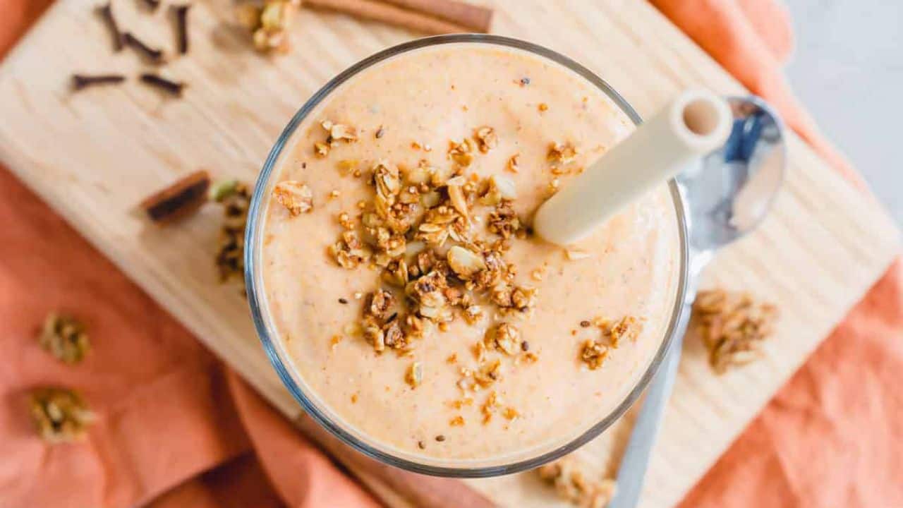 A butternut squash smoothie with cinnamon and nutmeg on a wooden cutting board.