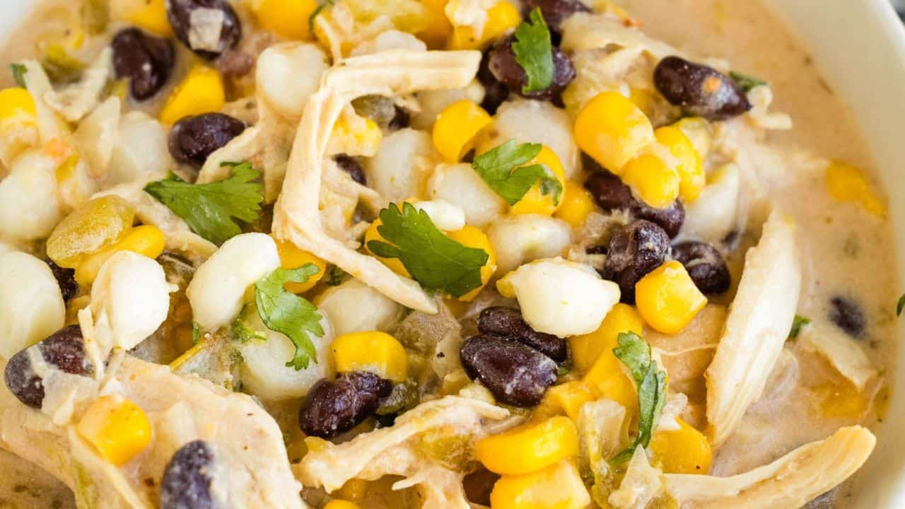 A bowl of mexican chicken chowder with corn and black beans.