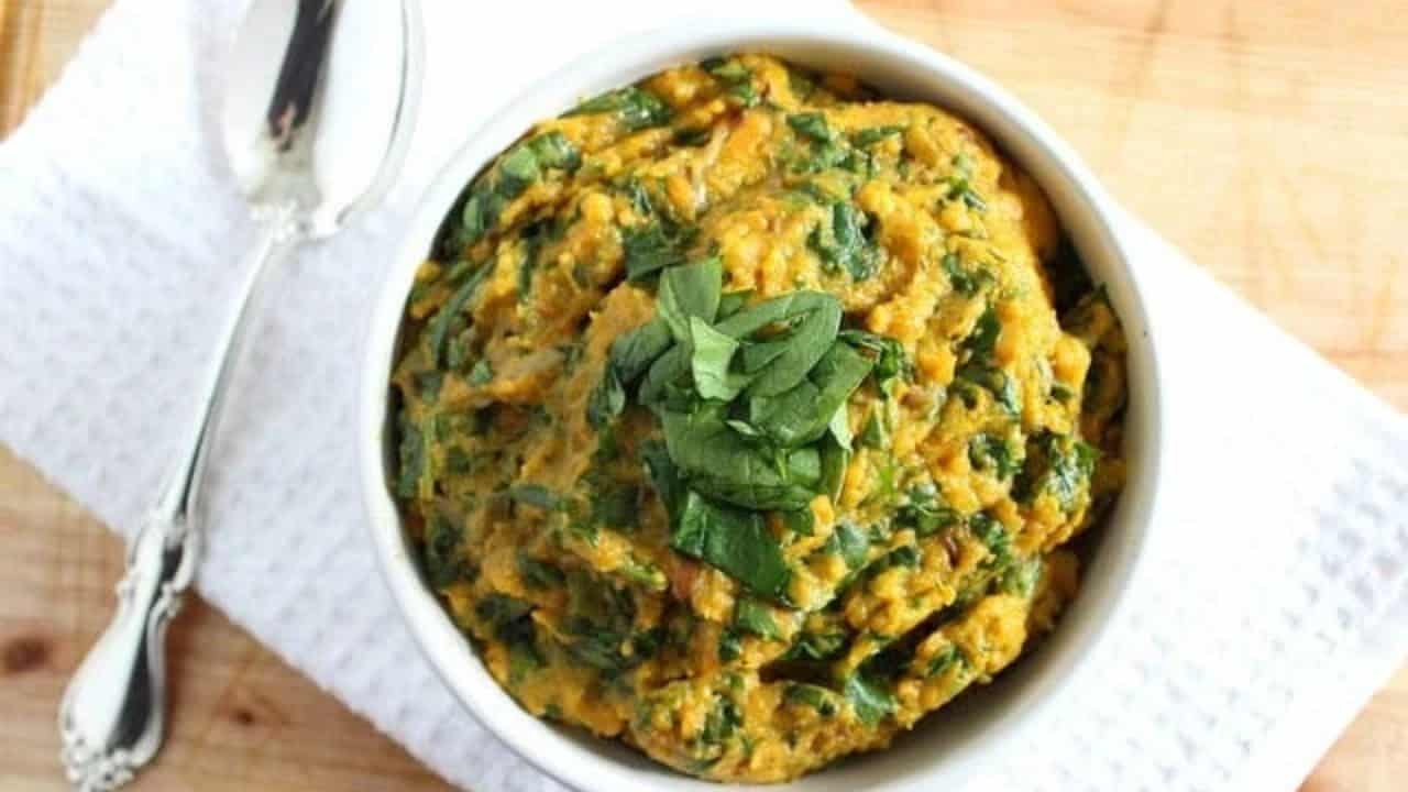 Mashed sweet potatoes with spinach and goat cheese in a white bowl.