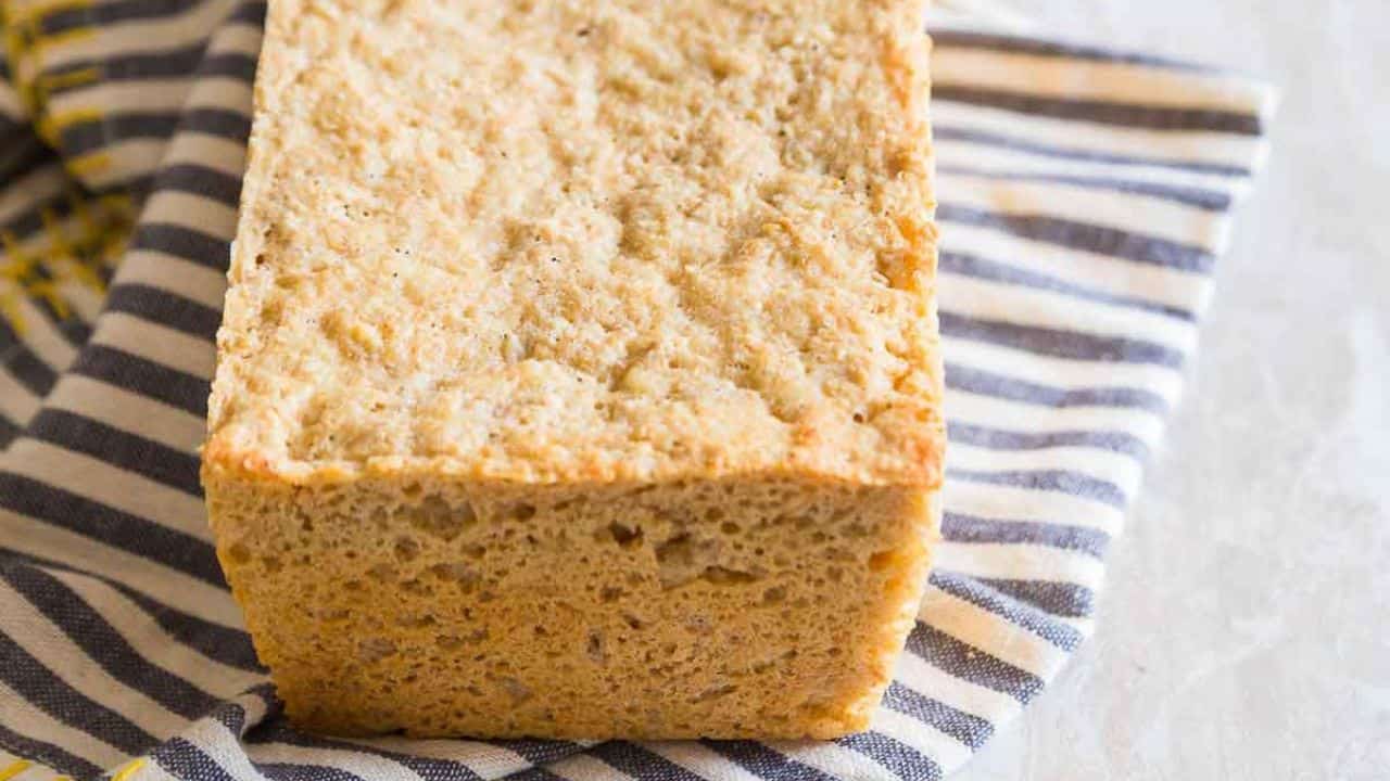 A loaf of sliced oat bread sitting on a towel.