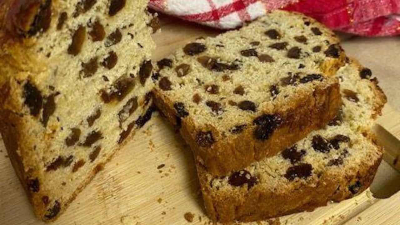 Round loaf of Irish soda bread on wooden board.