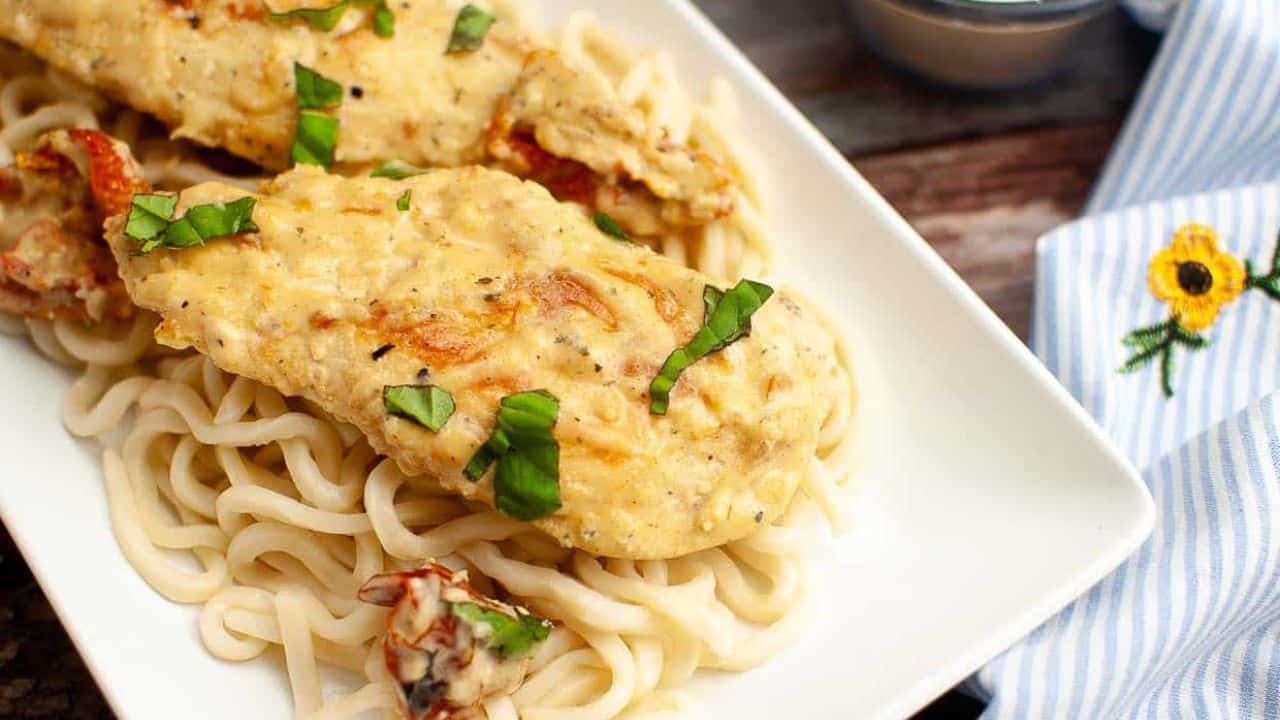 A plate of marry me chicken over pasta.