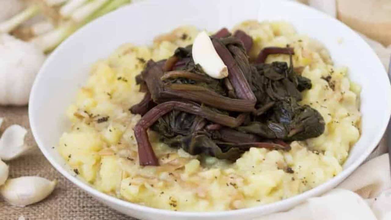 A bowl of mashed potatoes with garlic and thyme.