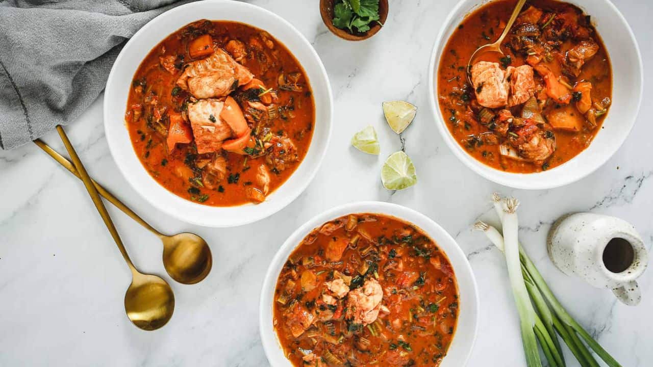 A bowl of stew with fish in it.