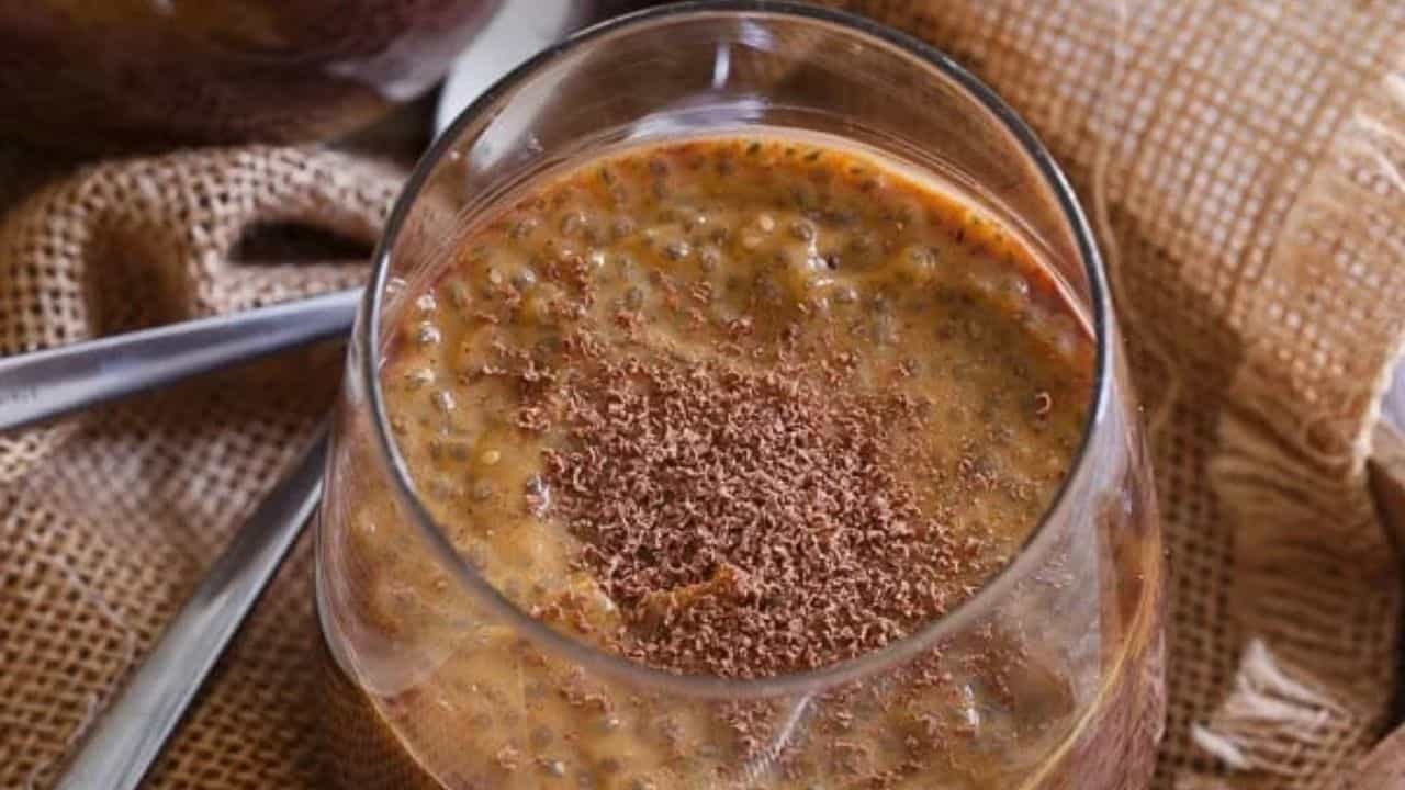 Chocolate pumpkin chia pudding in a glass dusted with cacao shavings.