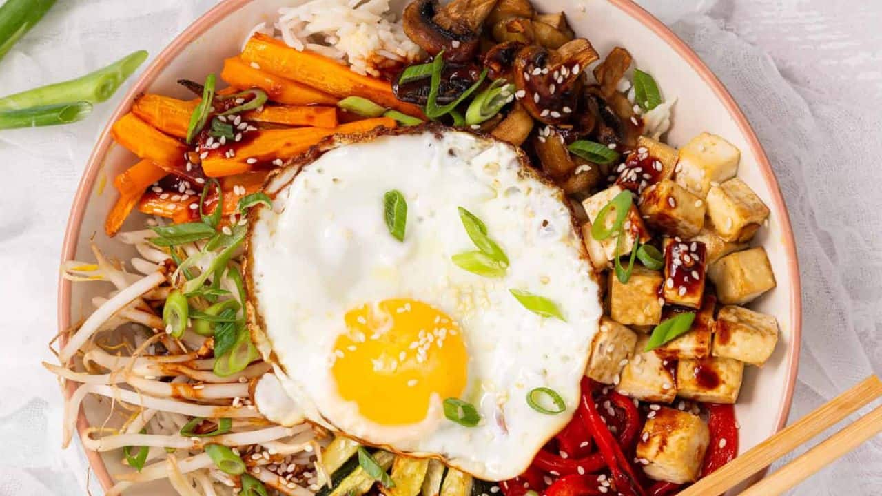 A bowl of Sheet Pan Bibimbap with a pair of chopsticks.