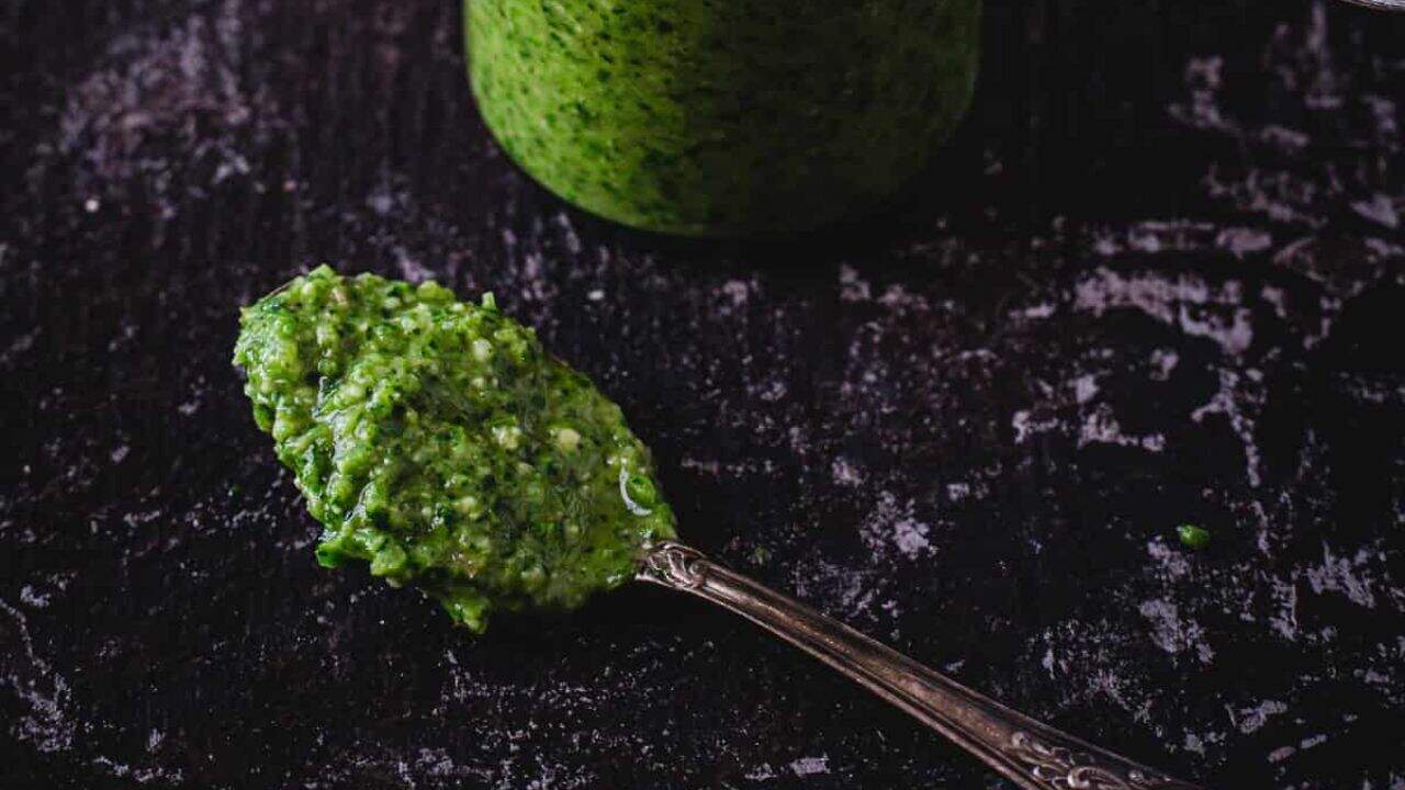 Green hot sauce on black background.