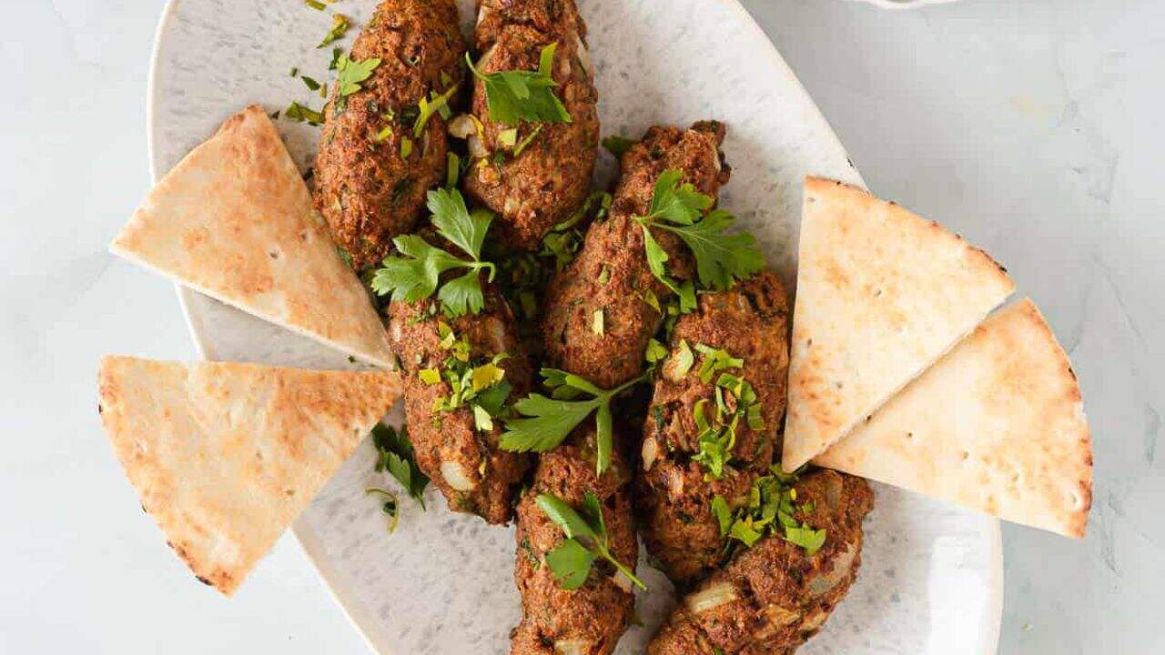 Kebabs on a plate with a lemon wedge.