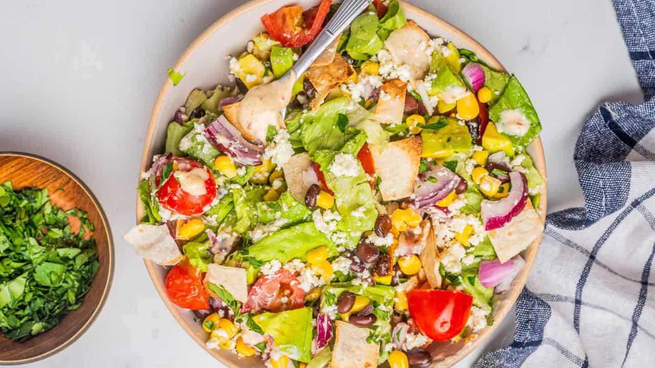 An overhead image of veggie taco salad in a bowl with a fork.