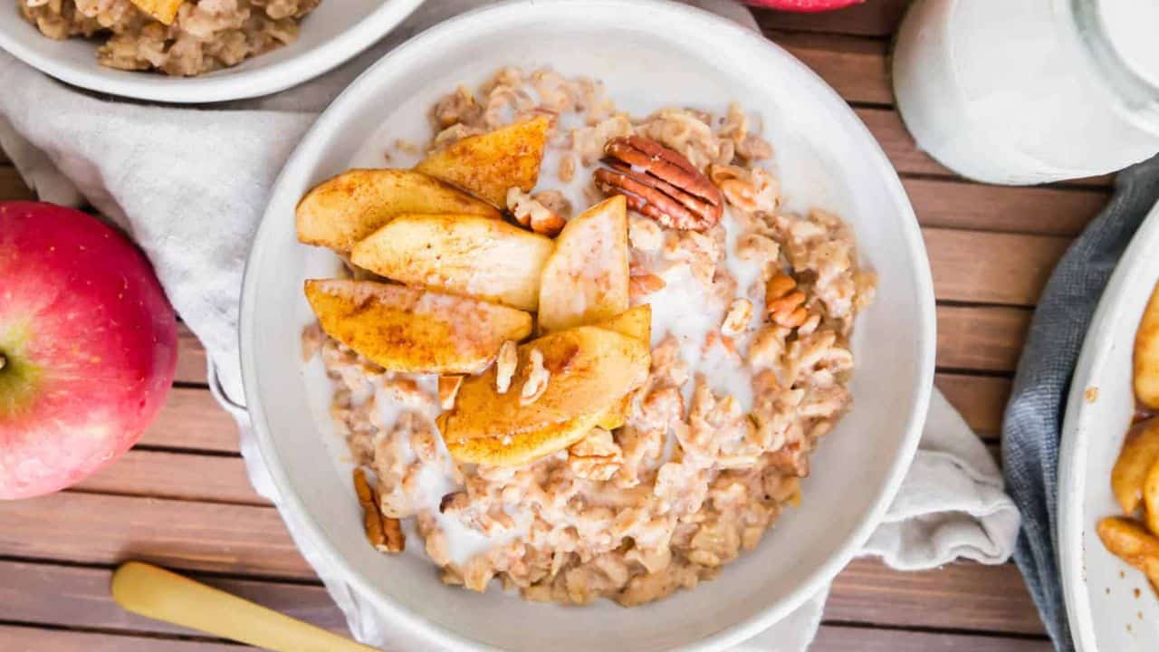 Creamy apple cinnamon oatmeal in a bowl with maple apple slices.