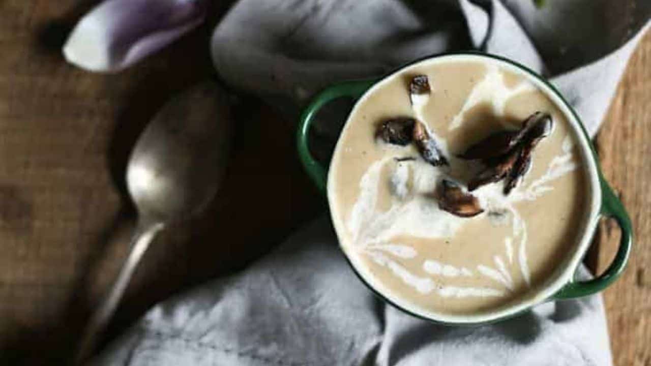 Two bowls of soup on a wooden table.