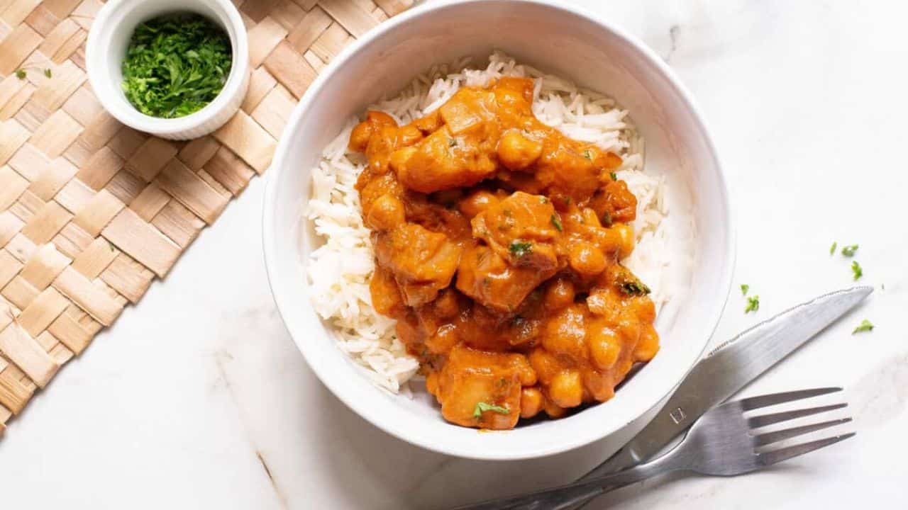 A bowl of rice topped with chickpea peanut butter curry.