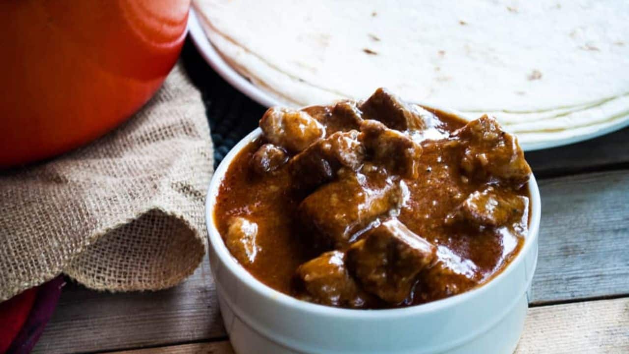 Beef chili colorado with tortilla with tortillas on the side.