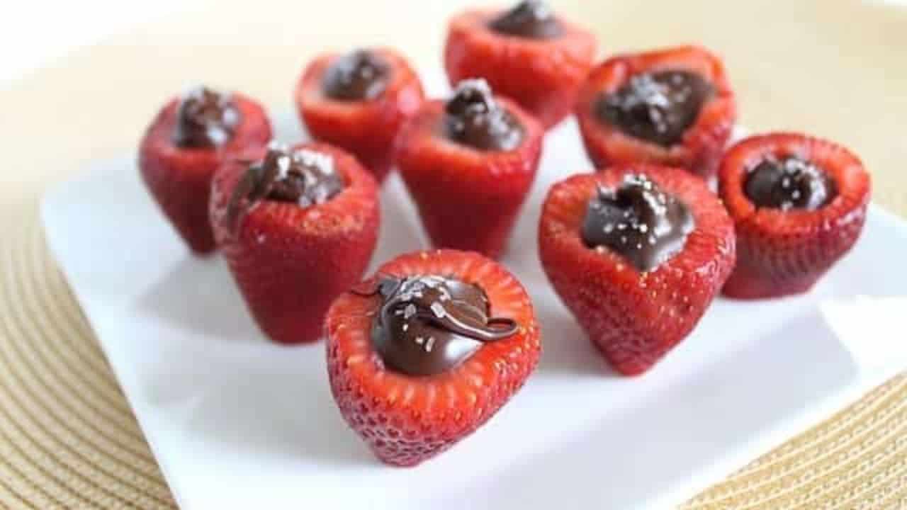 Chocolate stuffed strawberries on a white plate.