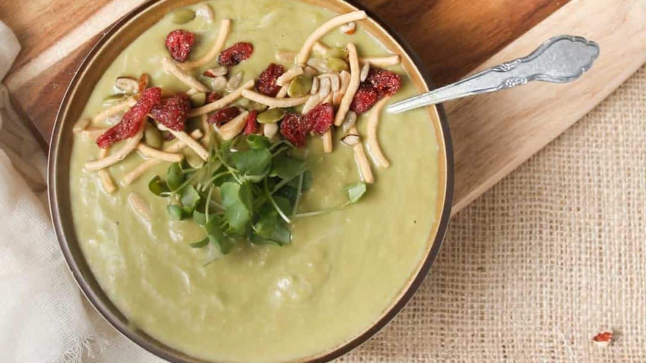 A bowl of soup on a wooden cutting board.