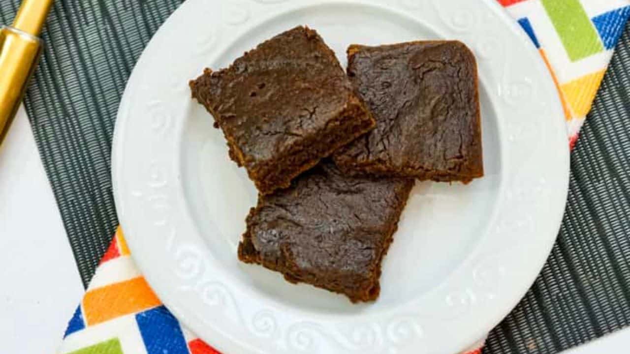 A chocolate brownie on a gold spatula.