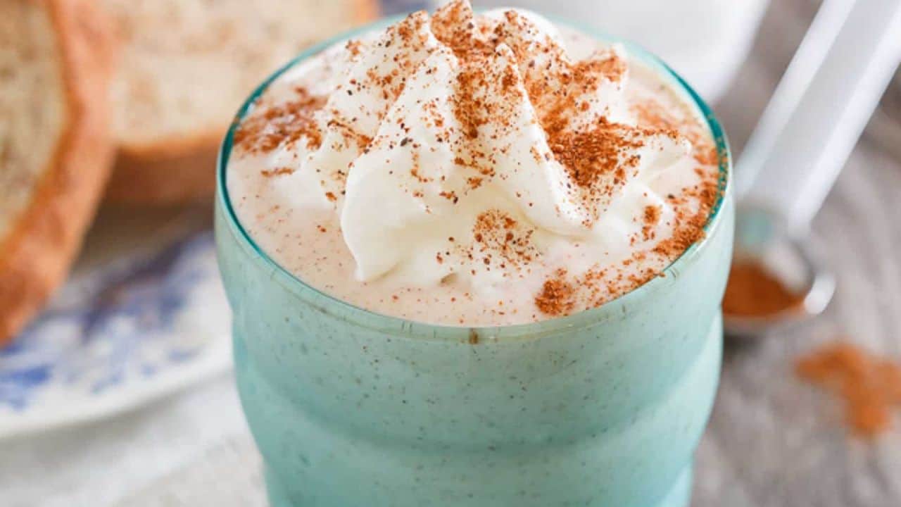 French toast smoothie in a blue green glass with cinnamon dusting.