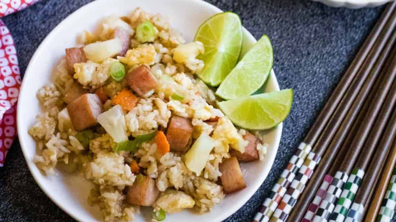 A plate of fried rice with limes.