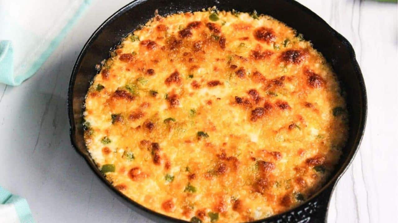A cast iron skillet filled with a cheesy dip.
