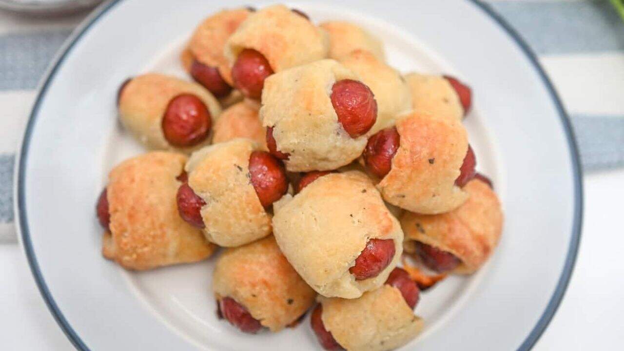 Hot dog buns with little smokies on a plate.