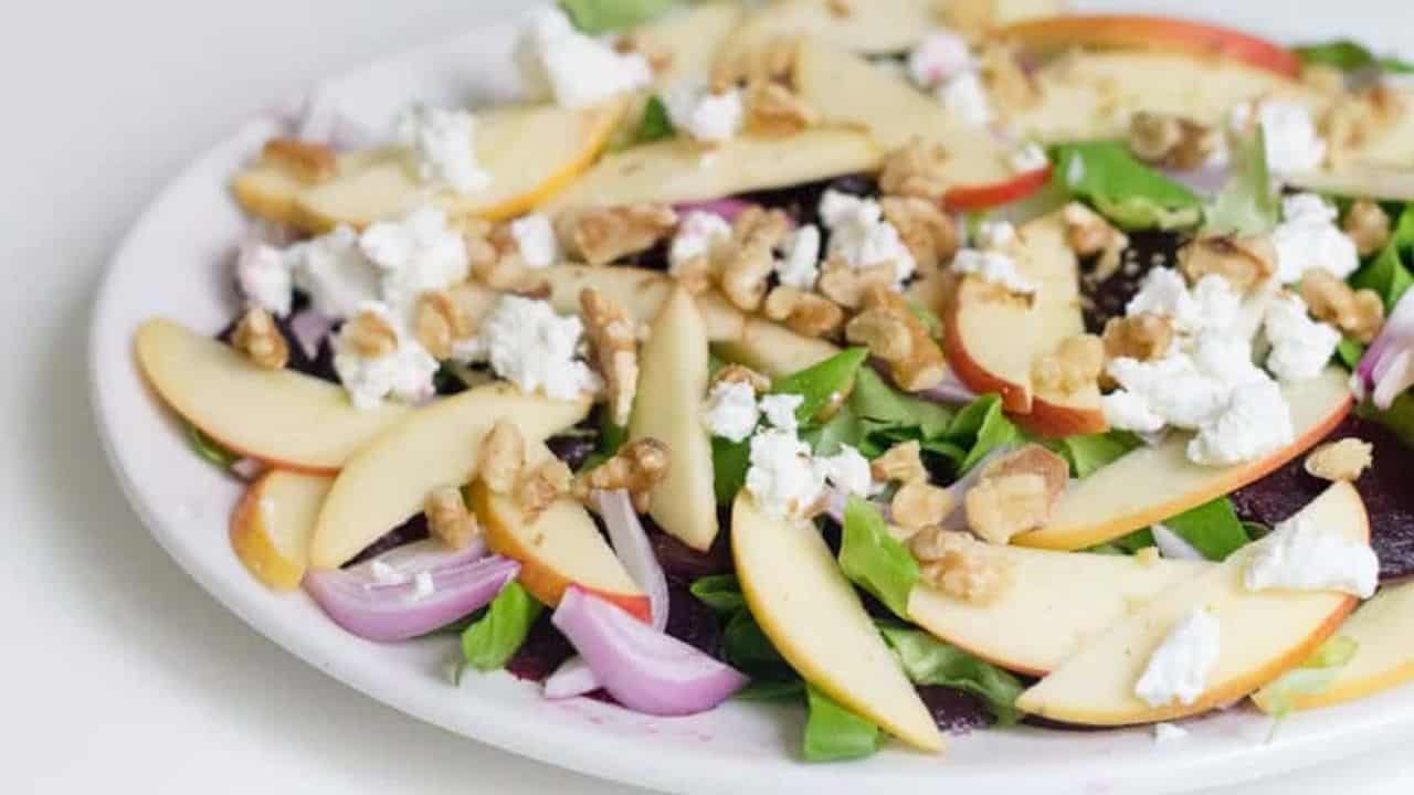 Side view of roasted beet salad on white platter.
