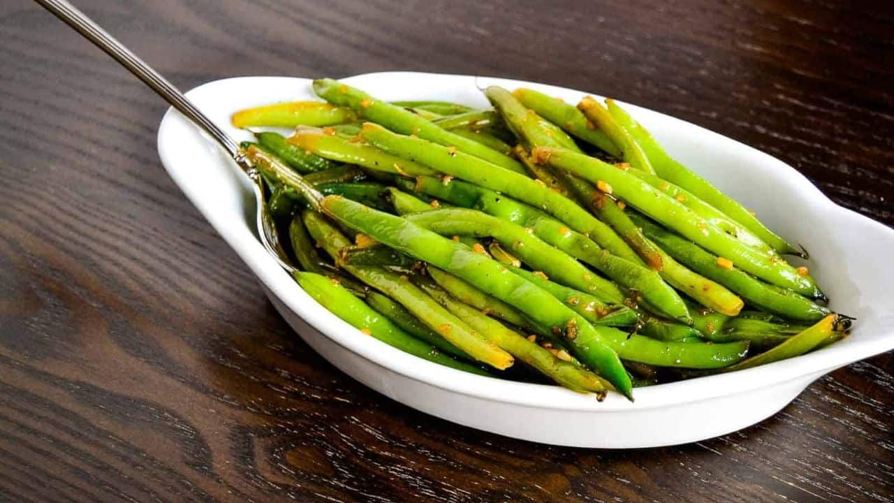 Greek Lemon Garlic Potatoes in a black dish with lemon in the background.
