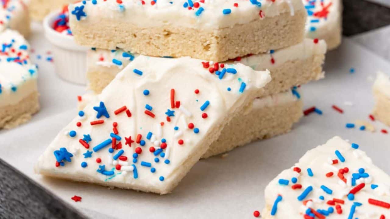 Red, white and blue sugar cookies stacked on a white plate.
