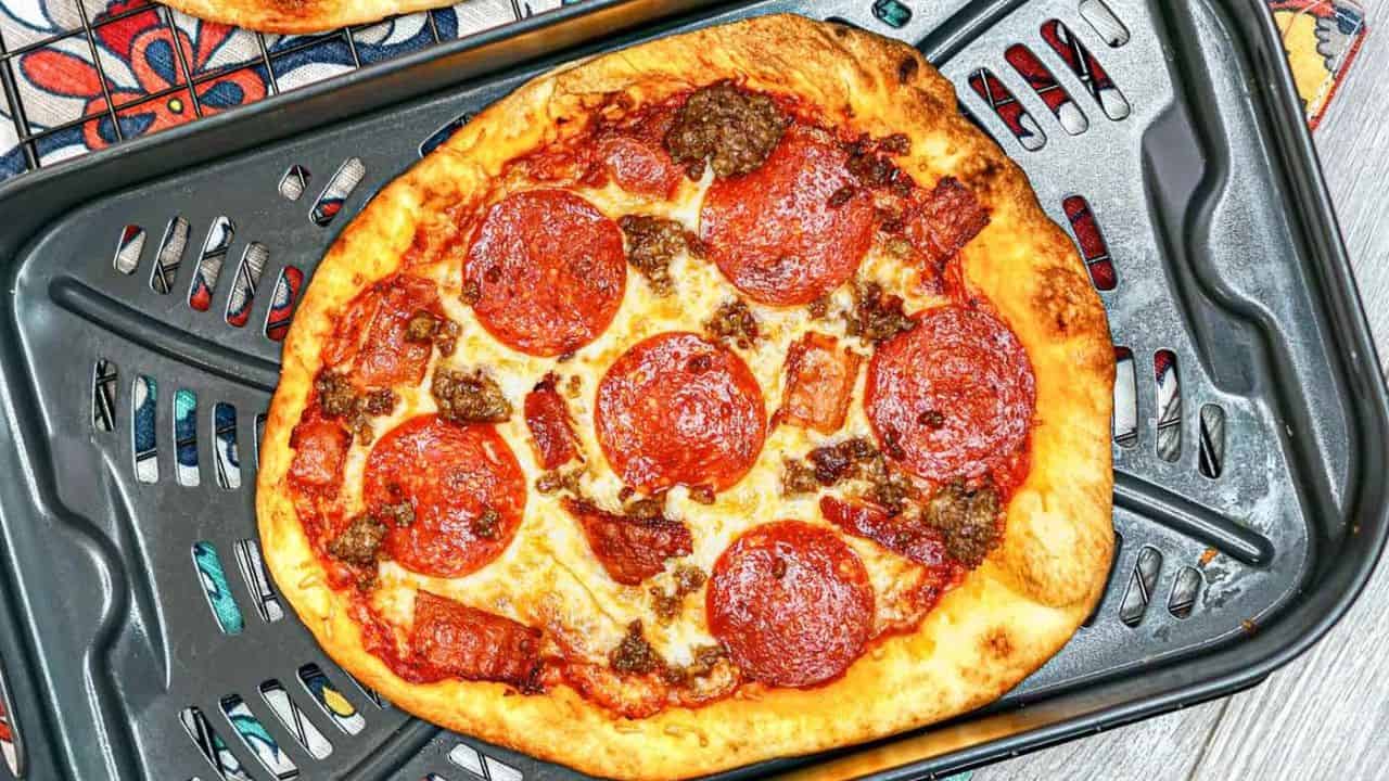 Chicken wings glistening with a rich, sticky barbecue sauce arranged on a white plate accompanied with a small bowl of creamy dipping sauce.