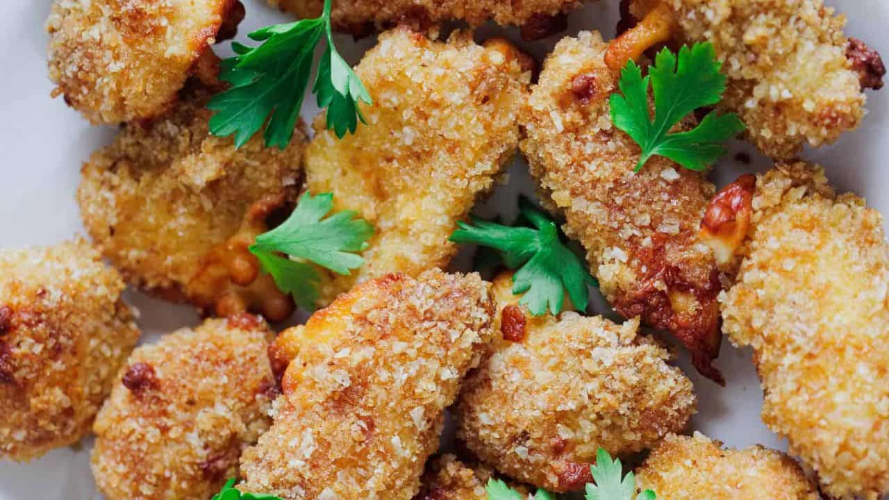 Golden-brown fried cheese curds garnished with fresh parsley.