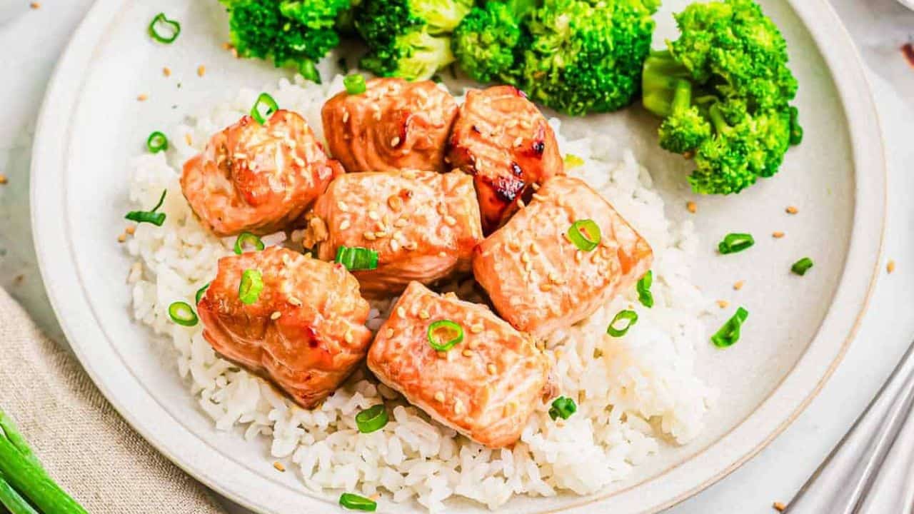 A plate with air fryer salmon bites, rice, broccoli and sauce on it.