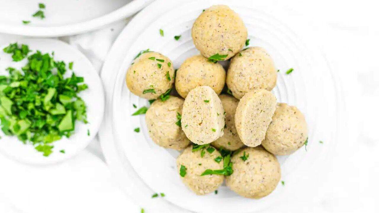 A plate of cooked dumpling balls garnished with chopped parsley.